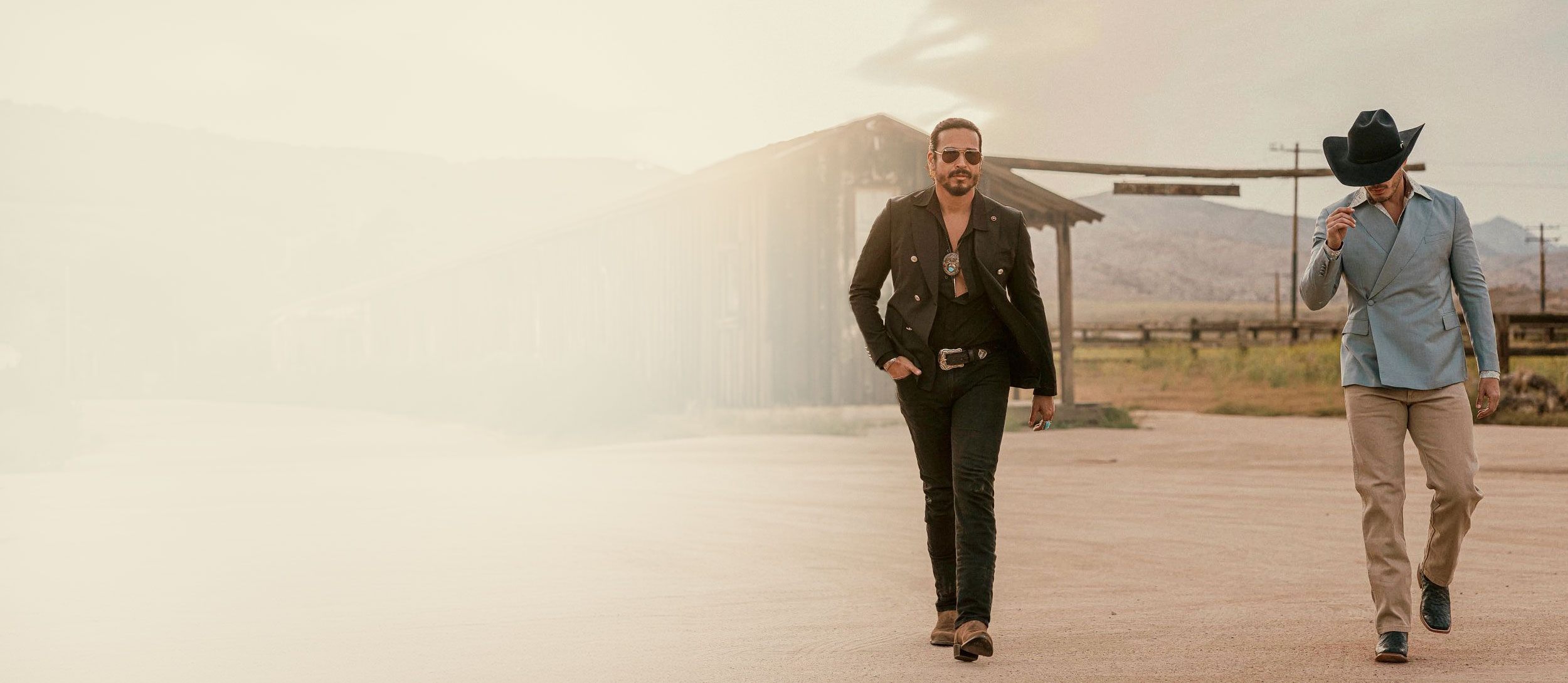 Two men walking in the desert wearing Tony Lama boots.